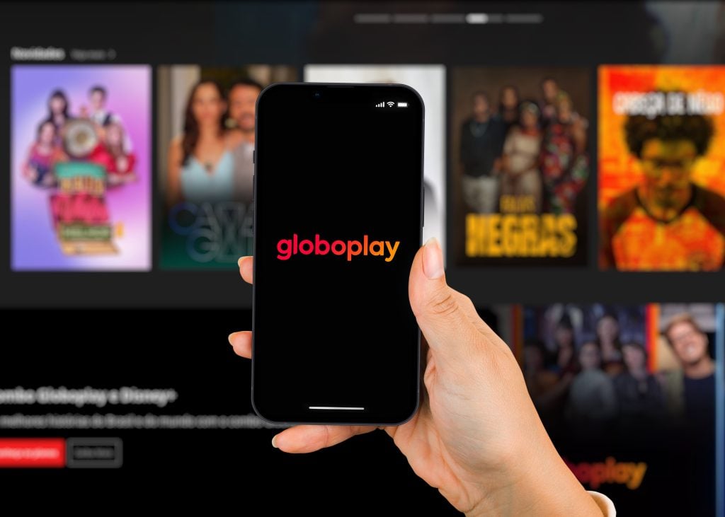 Fundo com vários filmes e séries e um celular pronto para começar a ver os melhores filmes do Globoplay