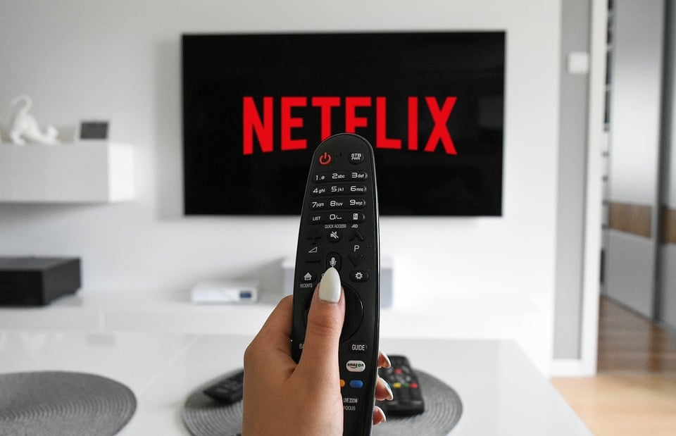 Controle apontado para a televisão com a Netflix na tela.