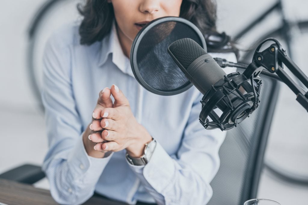 mulher falando em microfone de rádio