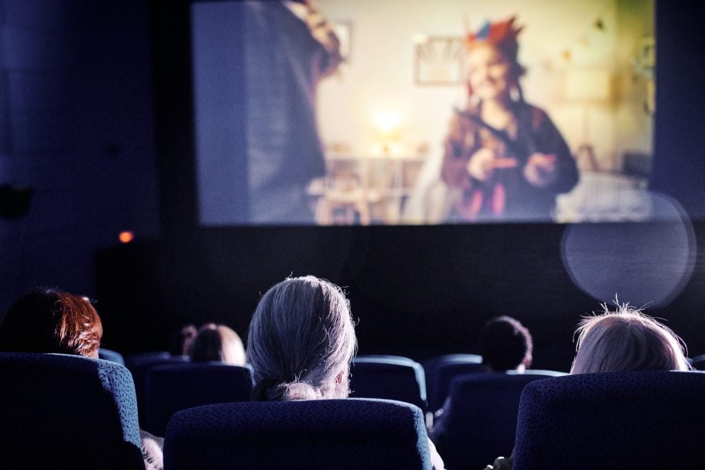 pessoas assistindo na tela do cinema