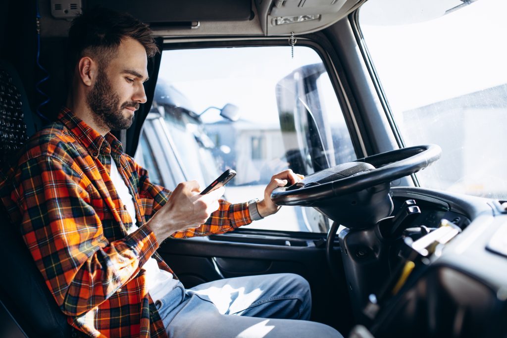 Man trucker driving in a cabin of his truck